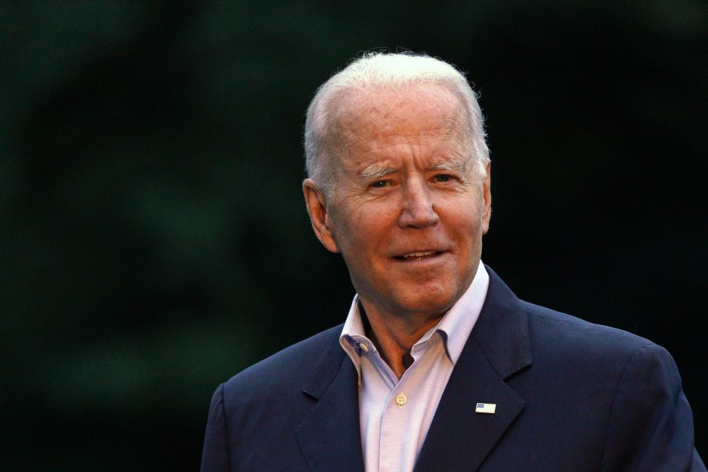 Joe Biden se uită direct spre cameră în timp ce este fotografiat.