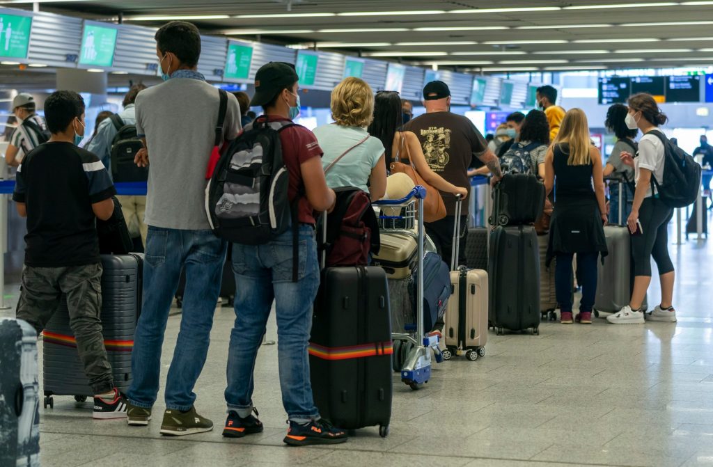 Oameni care stau la coadă în aeroport.