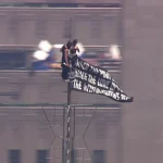 Imagini incredibile din New York: Două persoane mascate au urcat în vârful Empire State Building, cu un banner pentru pace: „Când puterea iubirii va învinge iubirea pentru putere, va fi pace în lume”